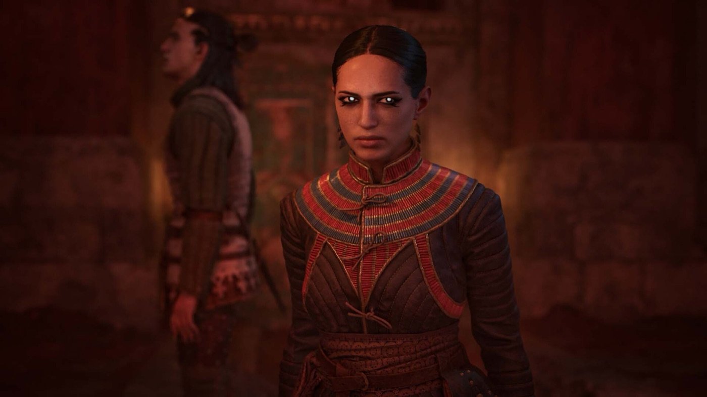 A stern character with pale eyes is lit by warm interior light